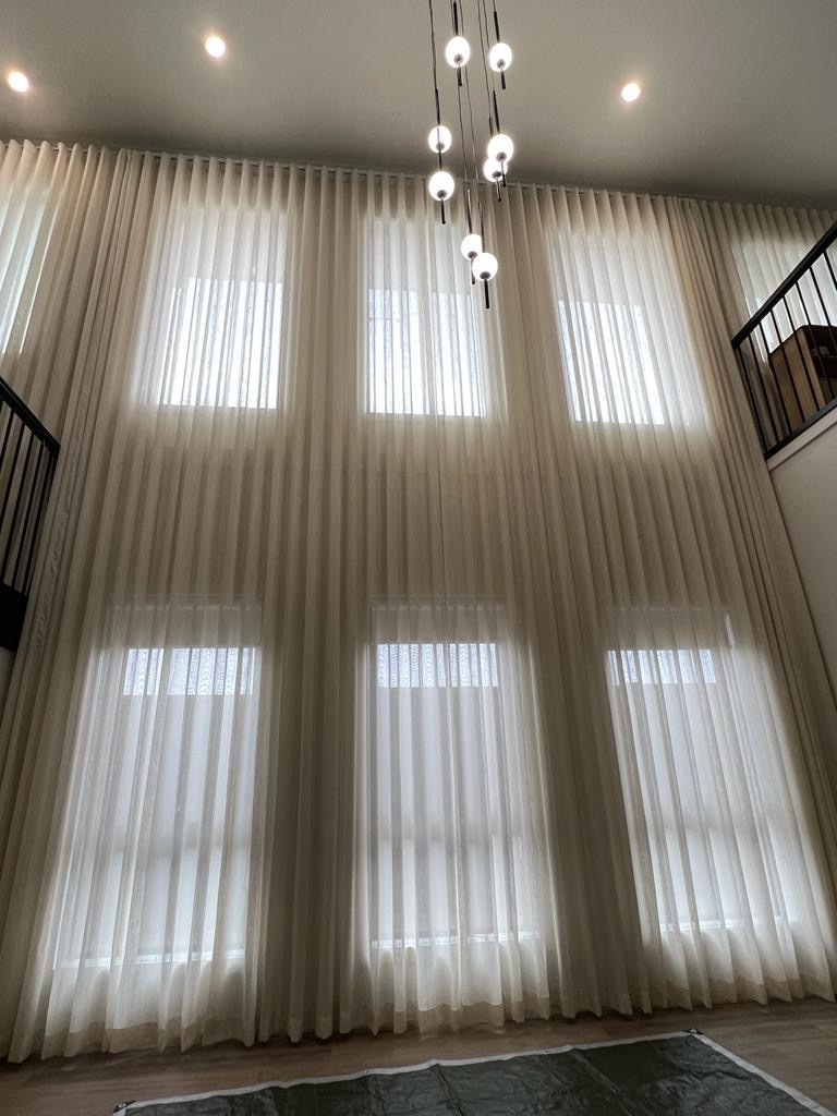 Full-height sheer curtains across a wall of tall windows